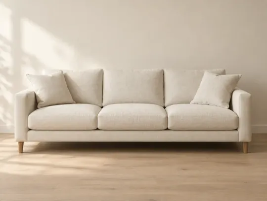 A cream linen three-seat sofa against a warm wall